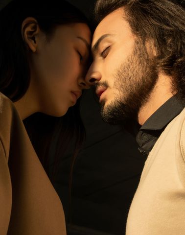 Man and woman leaning in for a kiss, capturing romantic tension and chemistry.