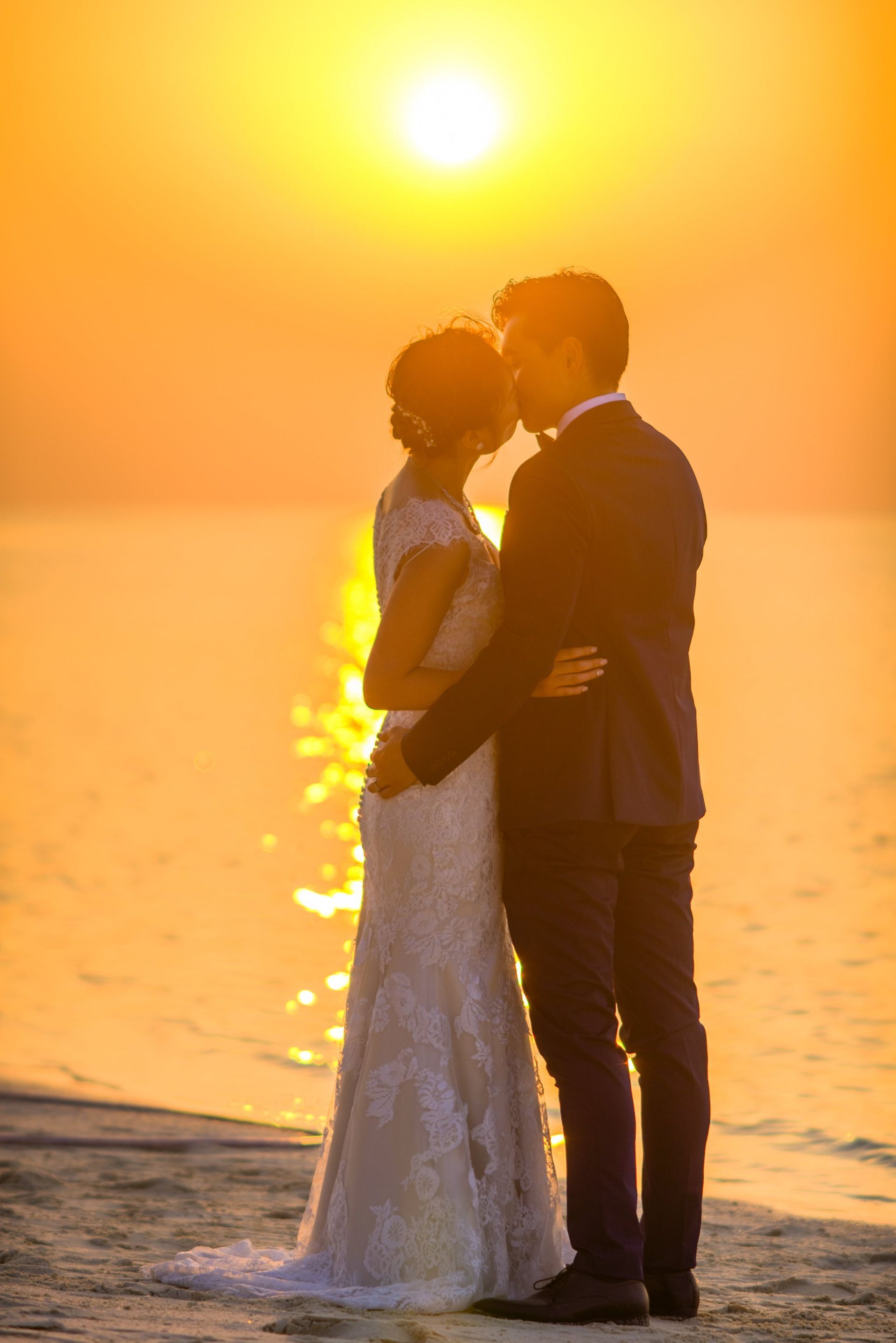 Newlywed couple kissing on the beach, a happy ending from personalized matchmaking services.