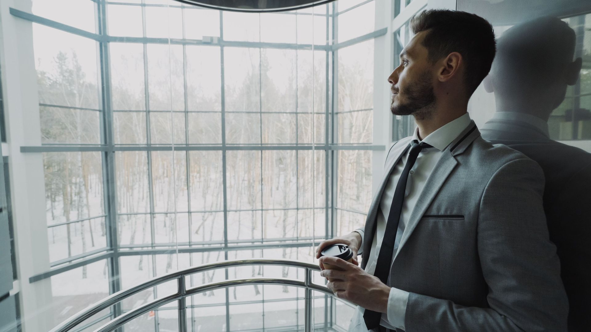 Professional in quiet reflection near a window, representing seeking a meaningful relationship