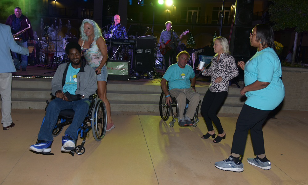A group of people in wheelchairs are dancing on a dance floor.