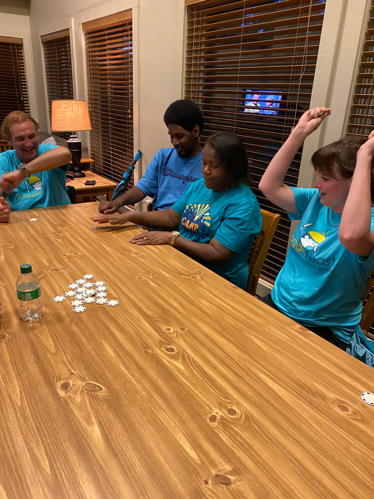 A group of people are sitting at a table playing a game.