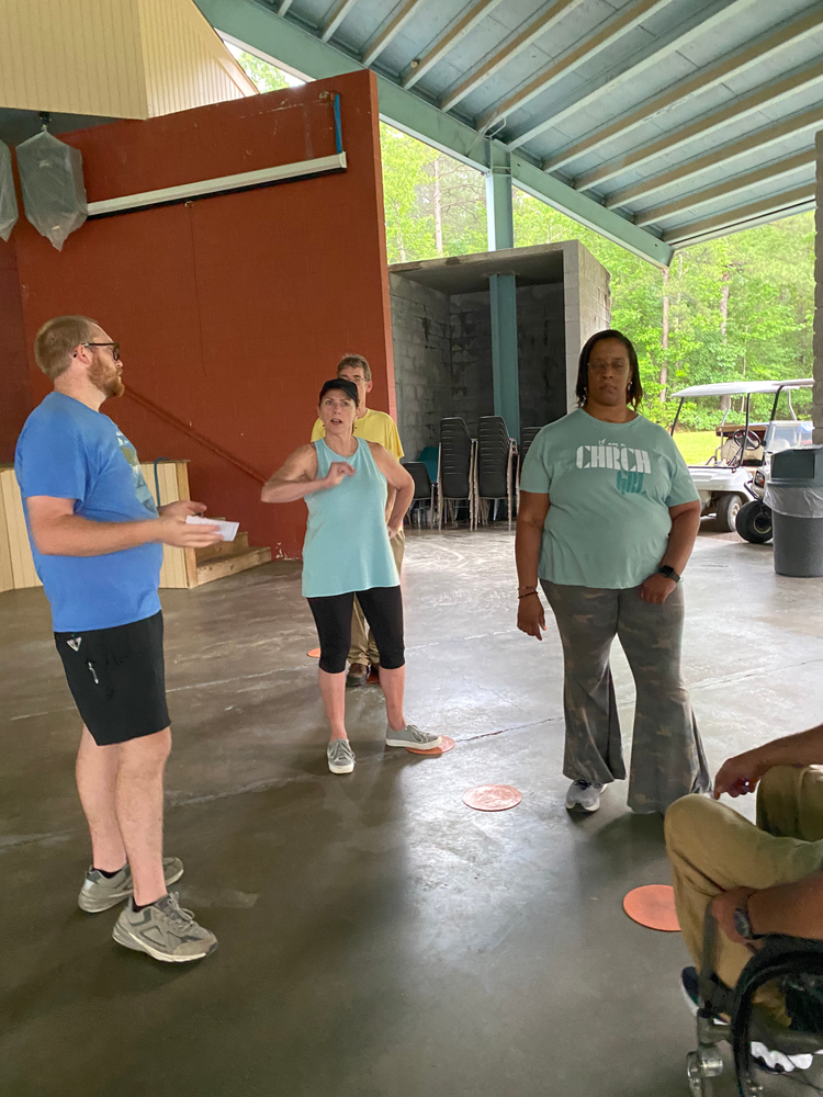 A group of people are standing in a room under a canopy.