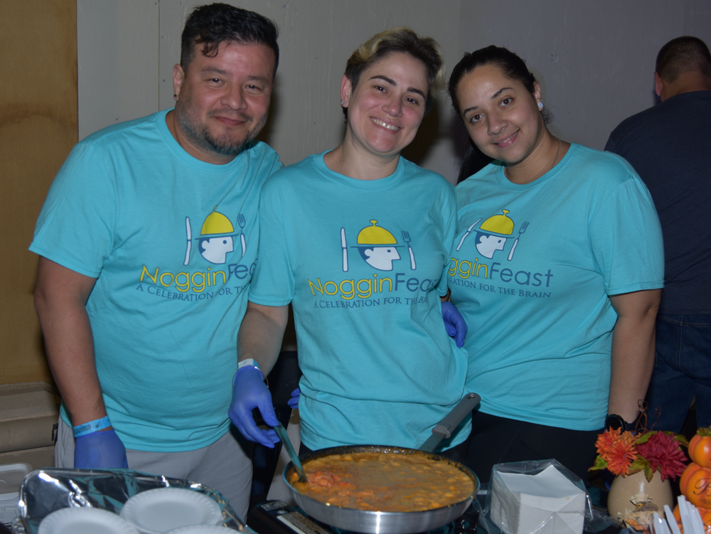 Three people wearing blue shirts with the word feast on them