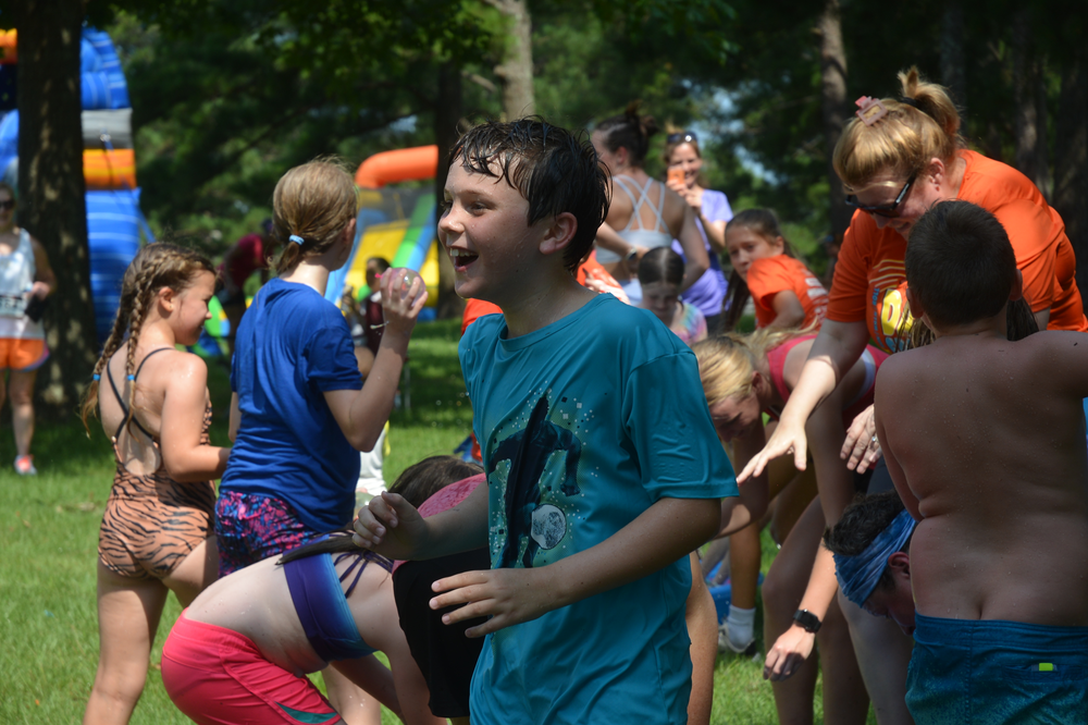 A group of children are playing with water in a park.