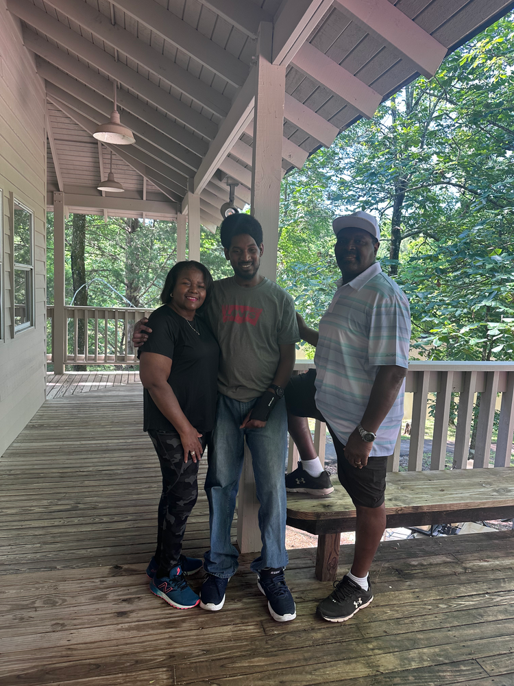 A group of people are posing for a picture on a porch.