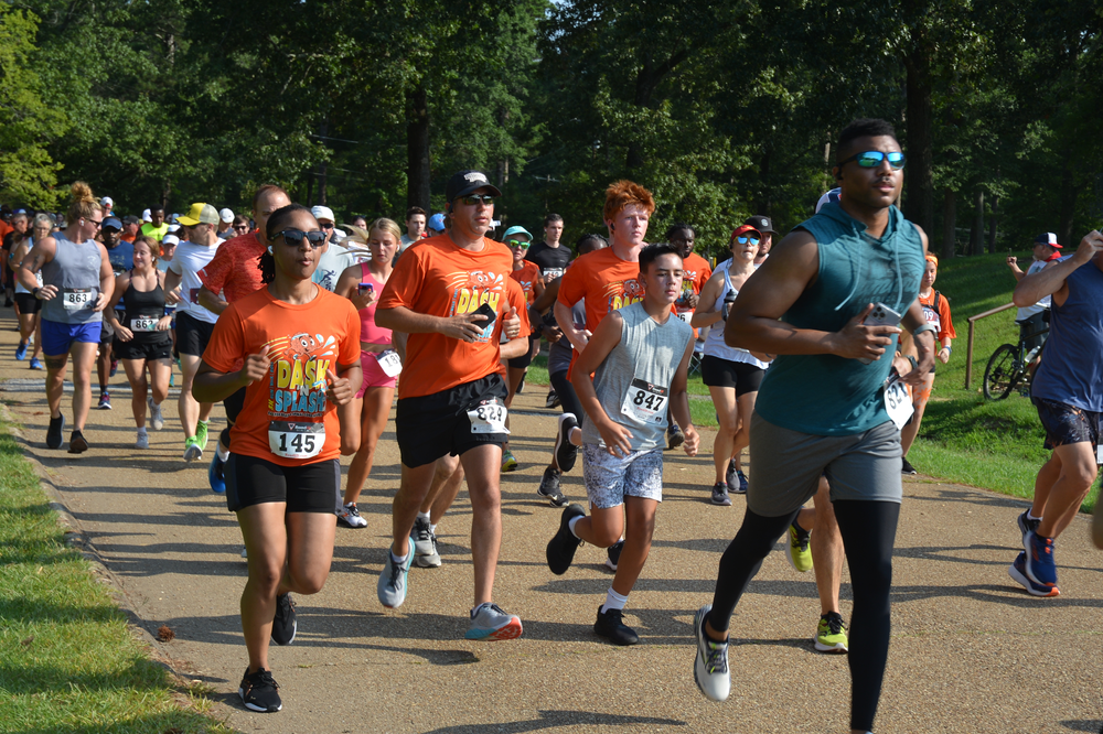 A group of people are running a race in a park.