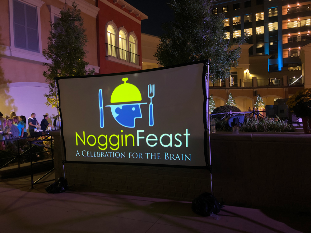 A large screen says noggin feast a celebration for the brain
