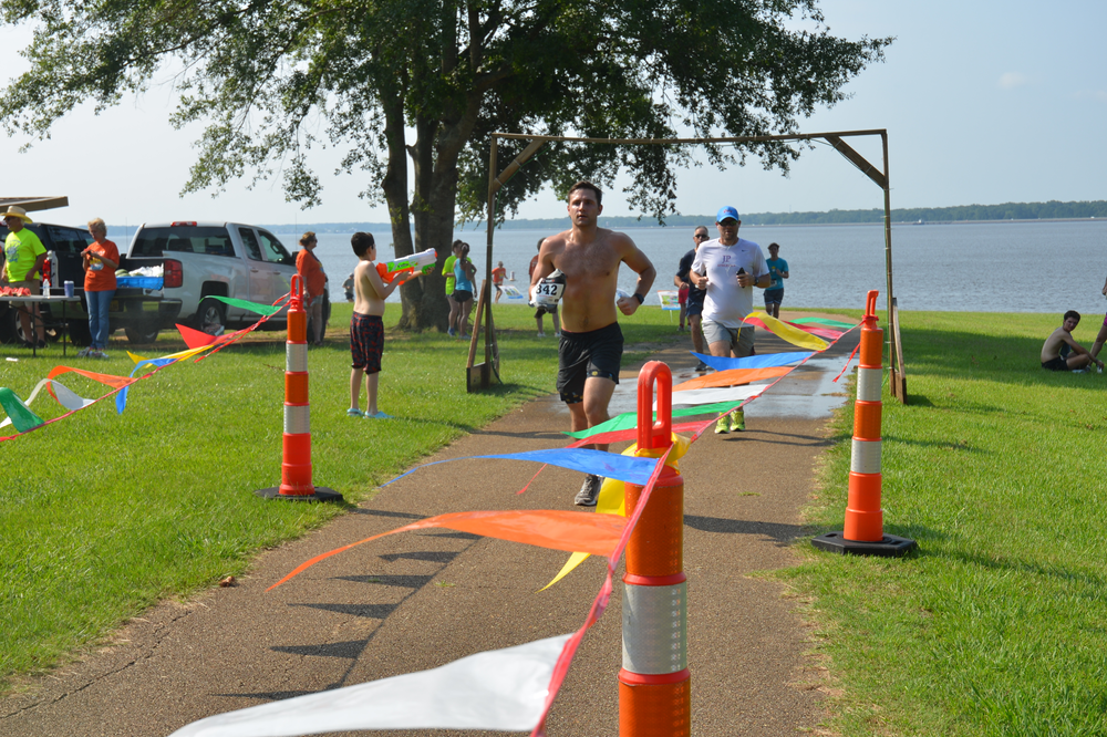 A man running on a path in a park near a body of water