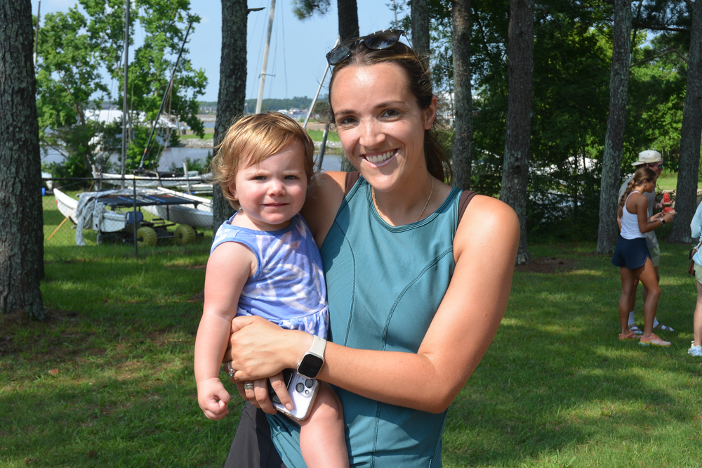 A woman is holding a little girl in her arms in a park.