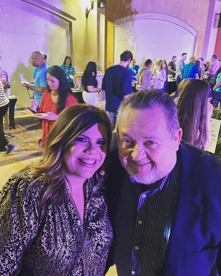 A man and a woman are posing for a picture at a party.