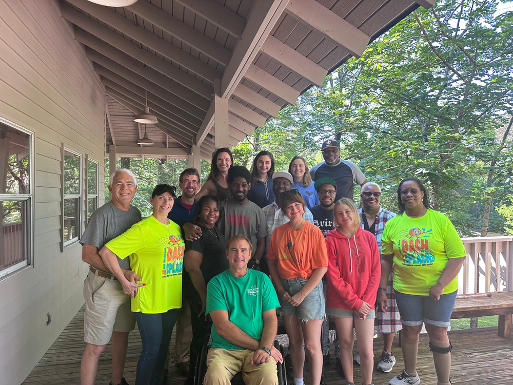 A group of people are posing for a picture on a porch.
