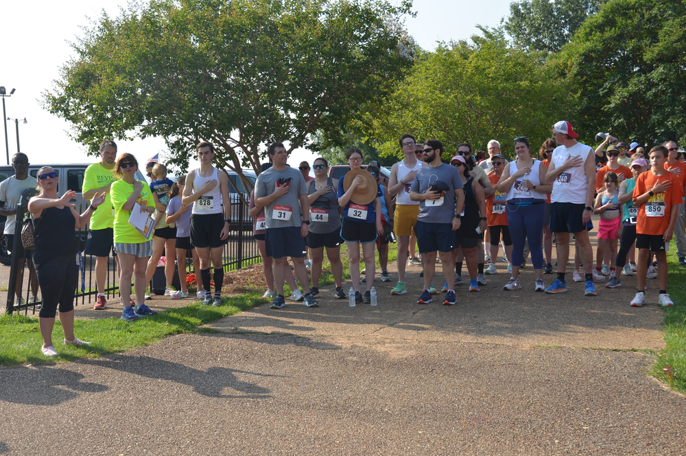A large group of people are standing in a park.