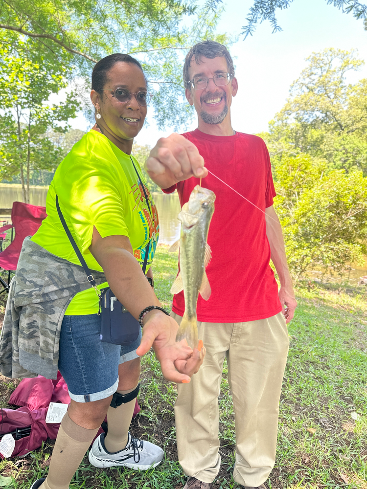 A man and a woman are holding a fish in their hands.