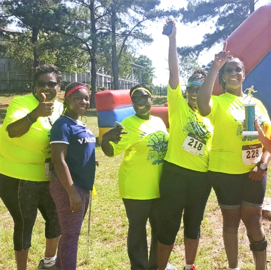 A group of women wearing neon yellow shirts with the number 218 on them