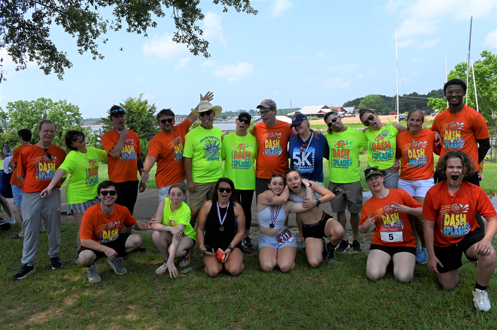 A group of people are posing for a picture in a park.