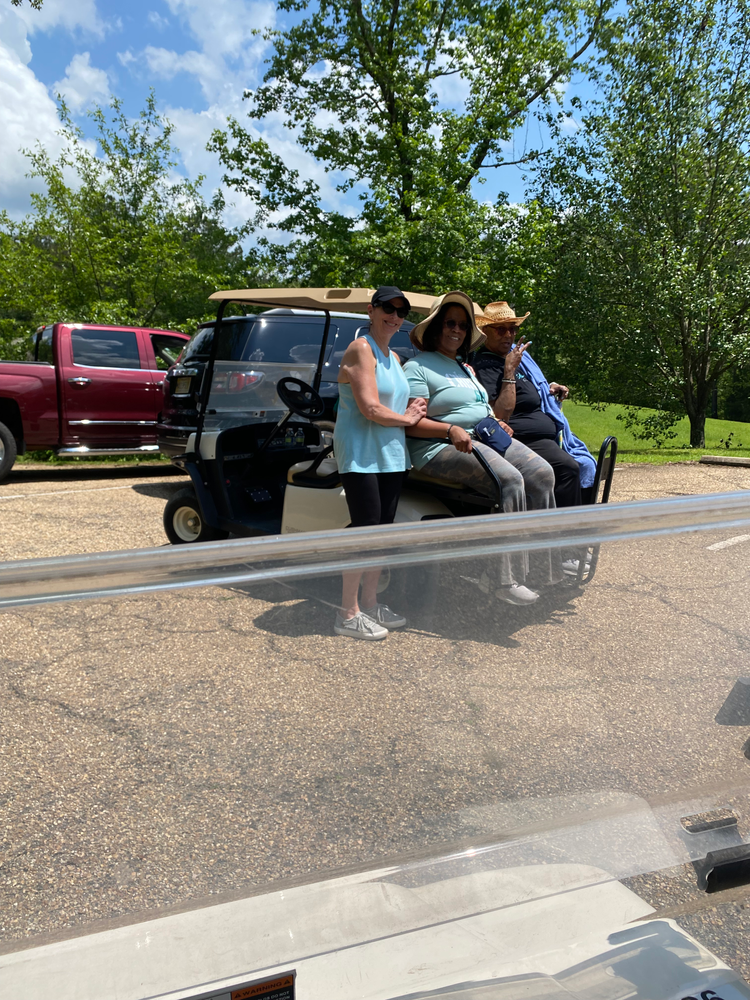 A group of people are sitting in a golf cart.
