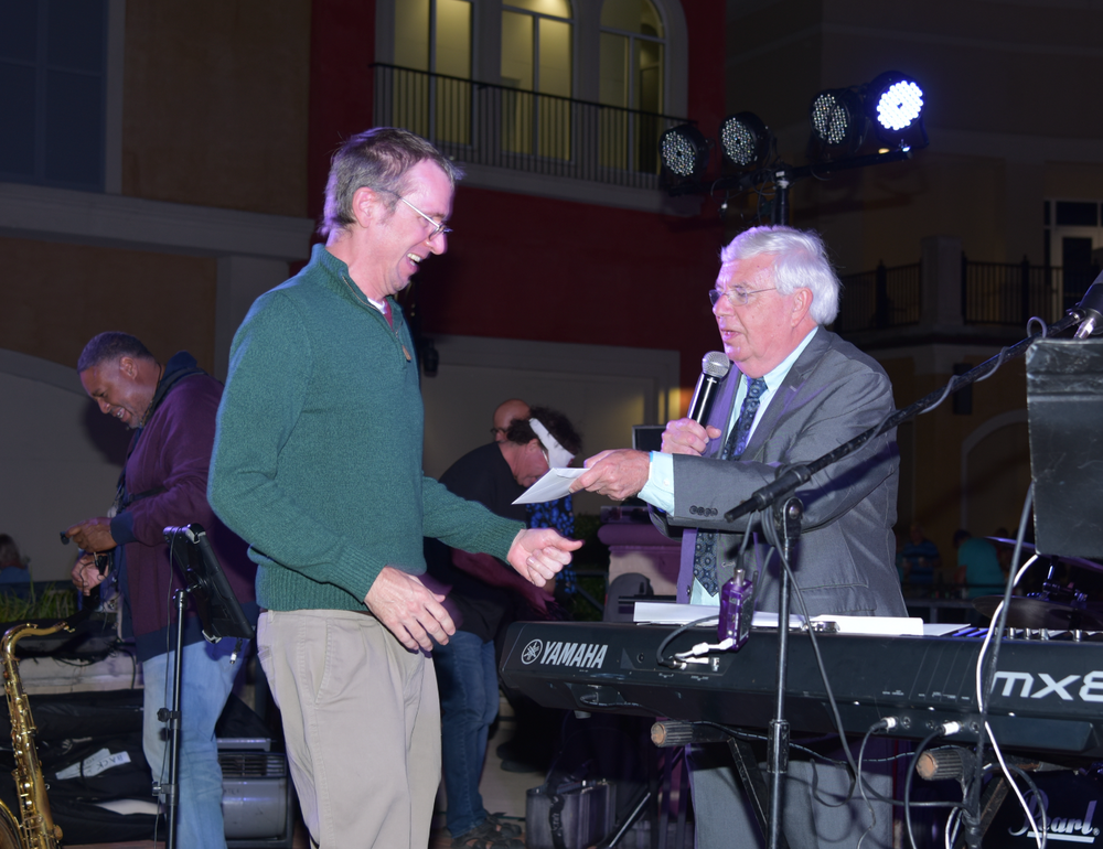 Two men are standing in front of a yamaha keyboard