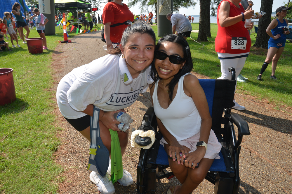 A woman in a wheelchair is posing for a picture with another woman