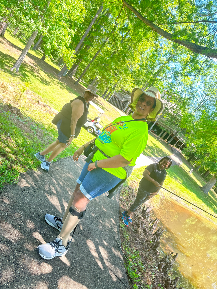 A woman with a prosthetic leg is walking down a path in a park.