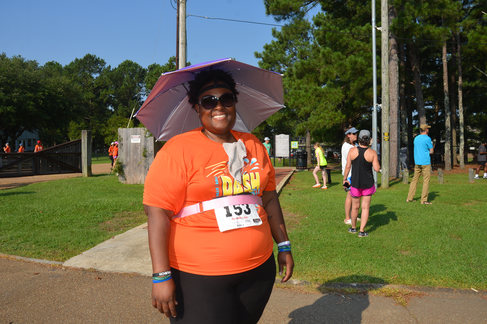 A woman wearing an orange shirt with the word dash on it