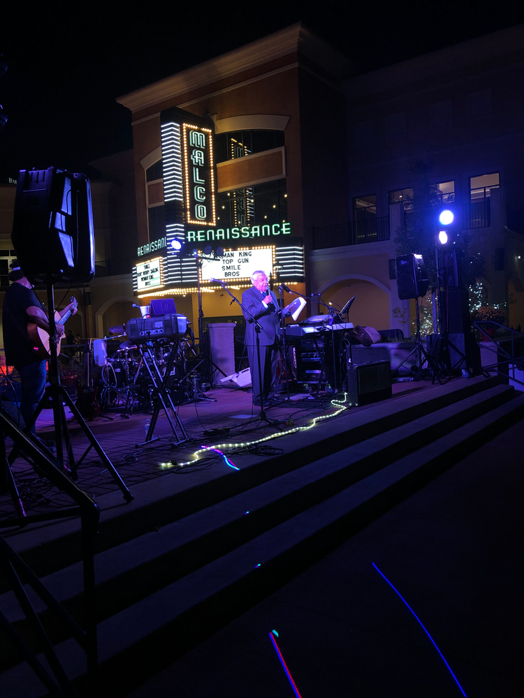 A man playing a keyboard in front of a sign that says renaissance
