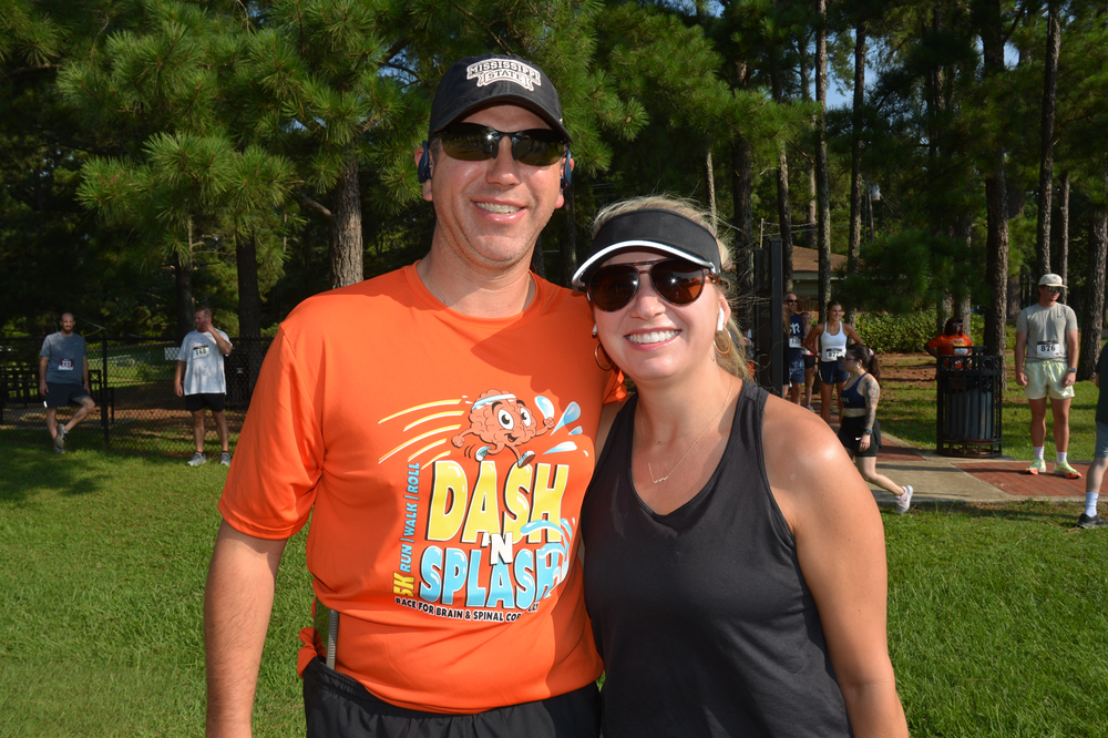 A man and a woman are posing for a picture in a park.