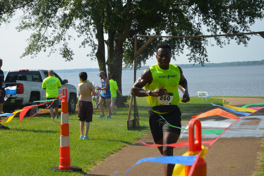 A man wearing a yellow shirt with the number 510 on it is running a race