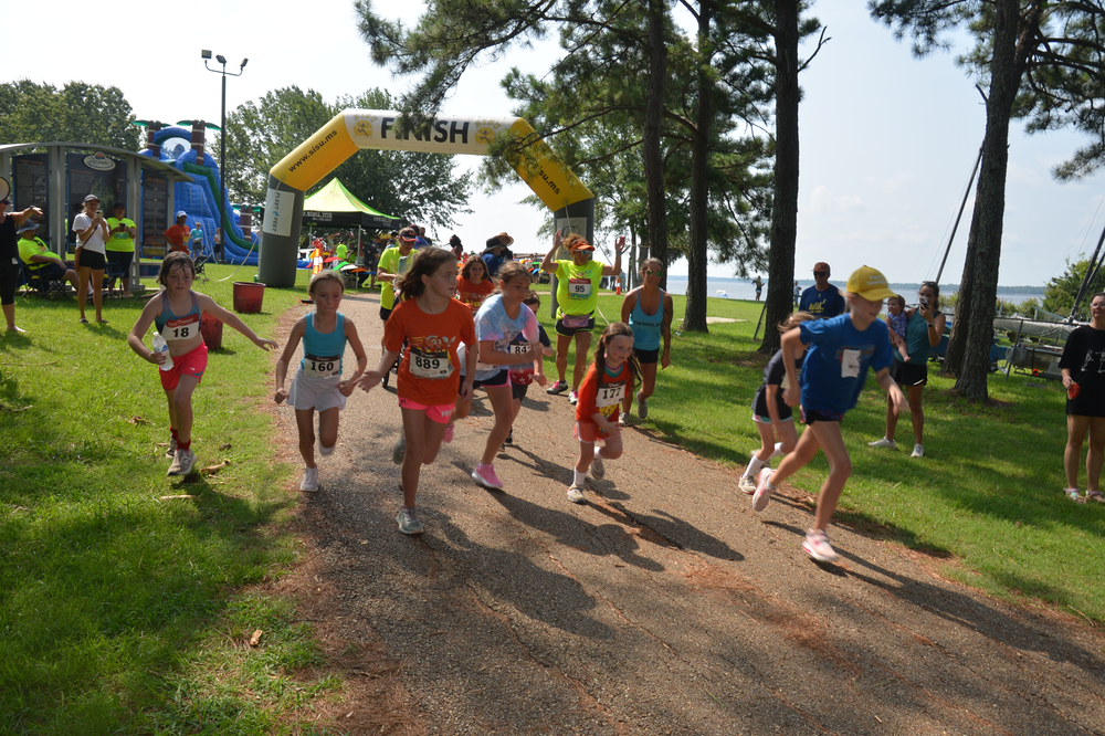 A group of people are running a race in a park.
