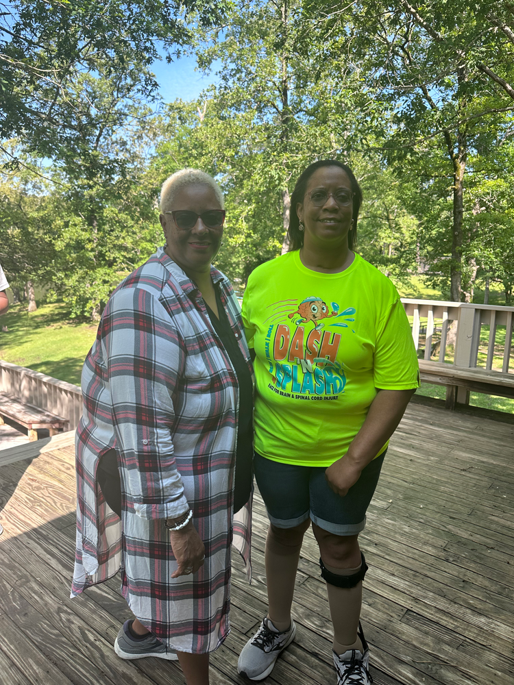 Two women are standing next to each other on a deck.