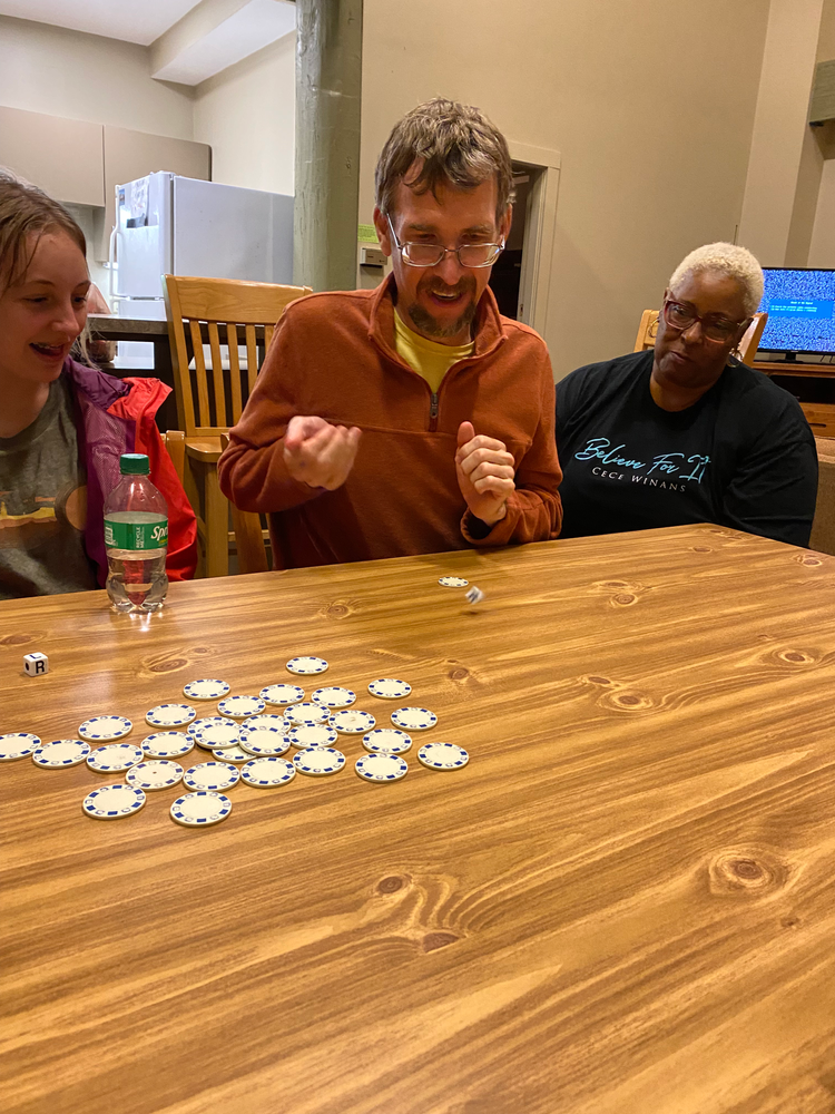 A group of people are sitting at a table playing a game of poker.