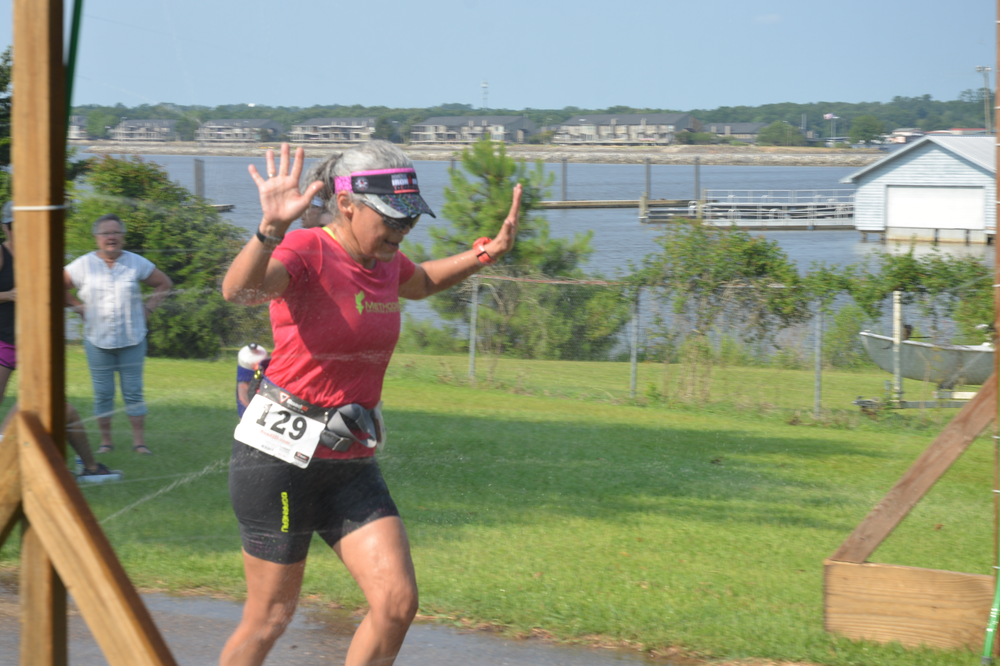 A woman is running in a race with the number 128 on her shirt.