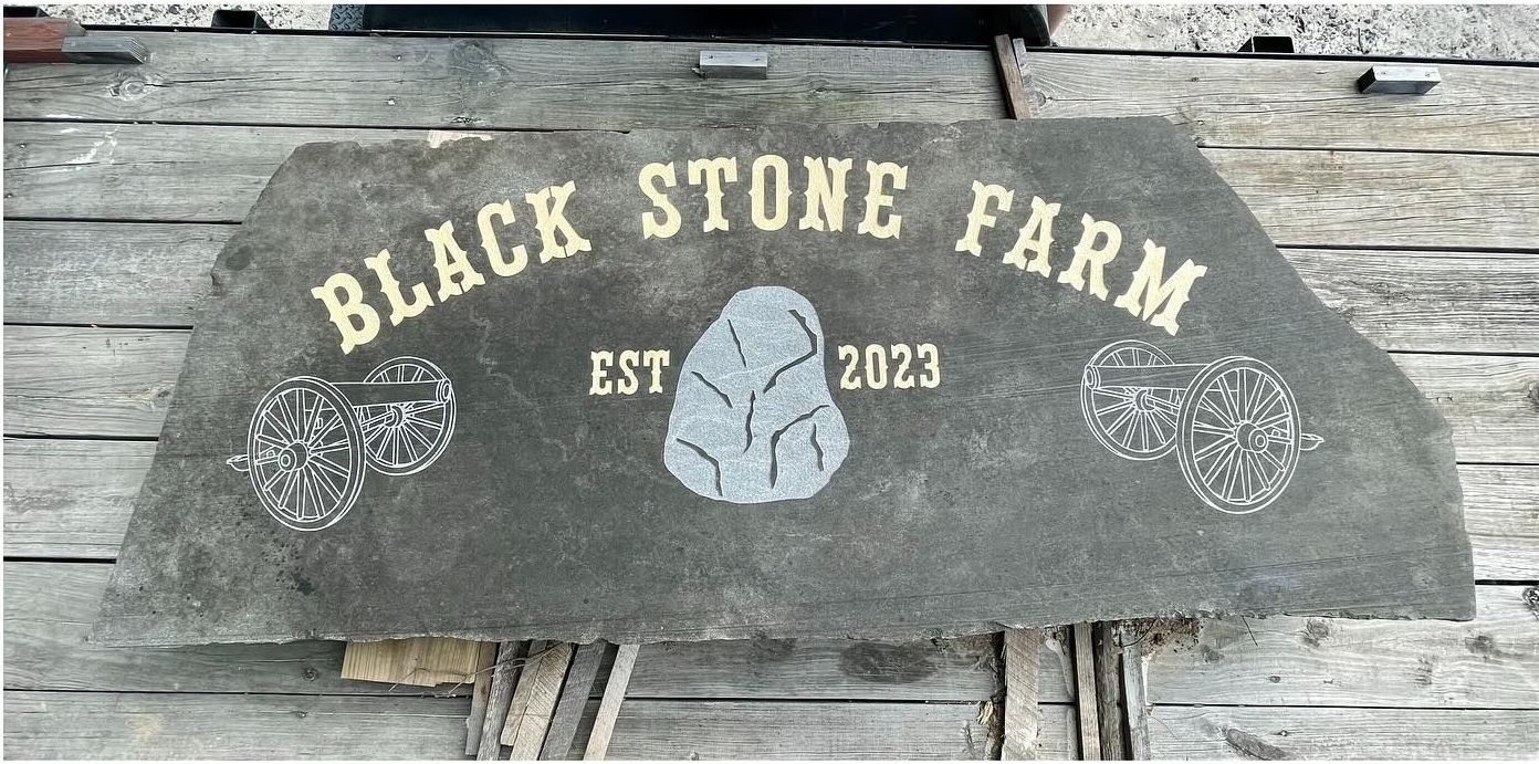 A sign that says black stone farm on it