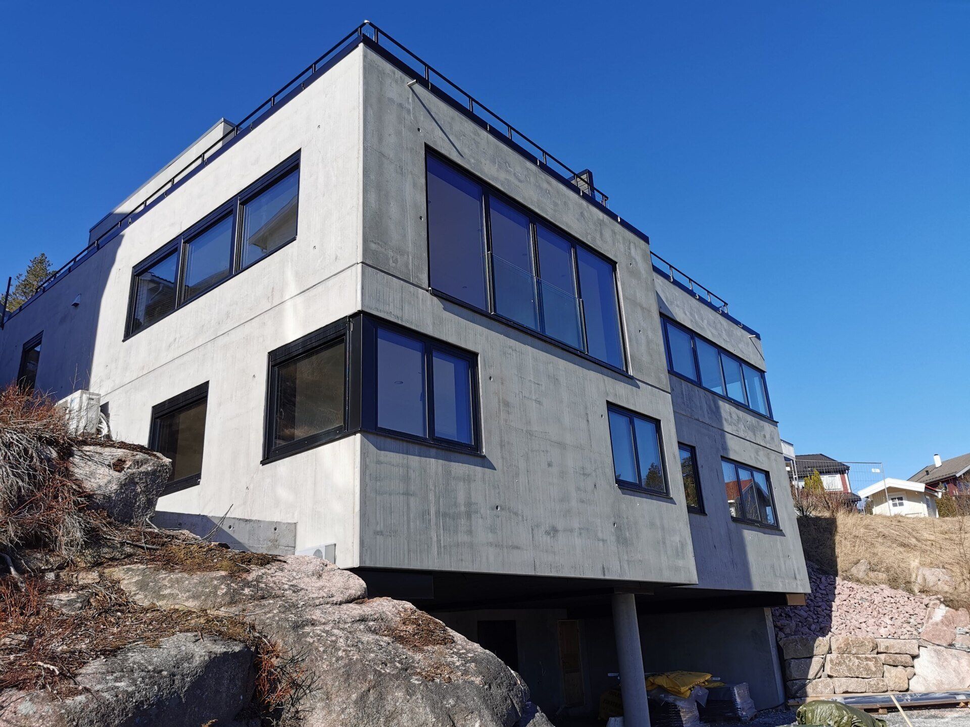 Tomannsbolig i betongelementer, fasade mot parkering og utsikt.