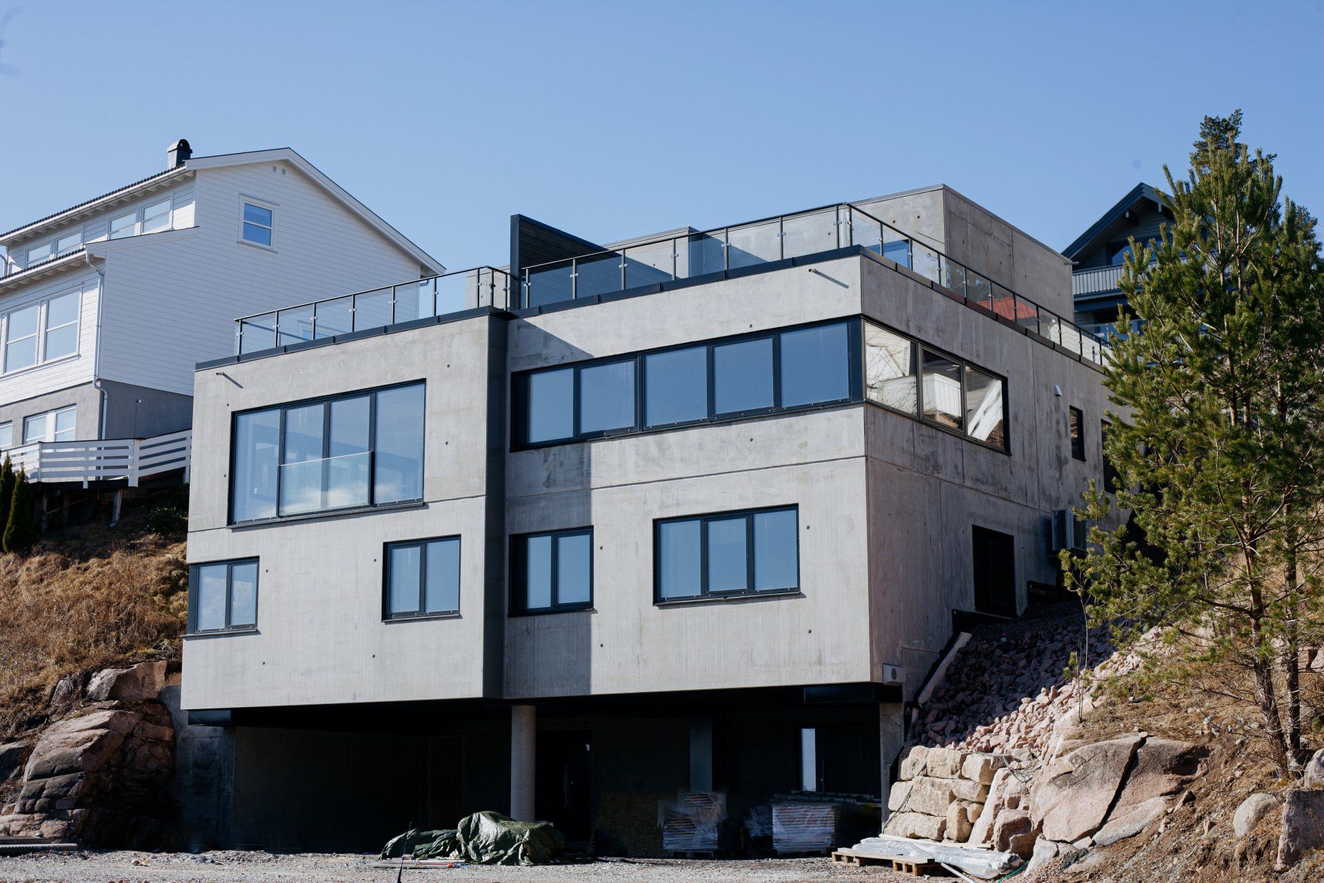 Tomannsbolig i betongelementer, fasade mot parkering og utsikt.