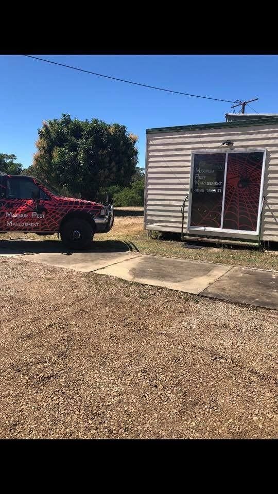 A Red Truck Is Parked In Front Of A Small House — Maximum Pest Management In Mareeba, QLD
