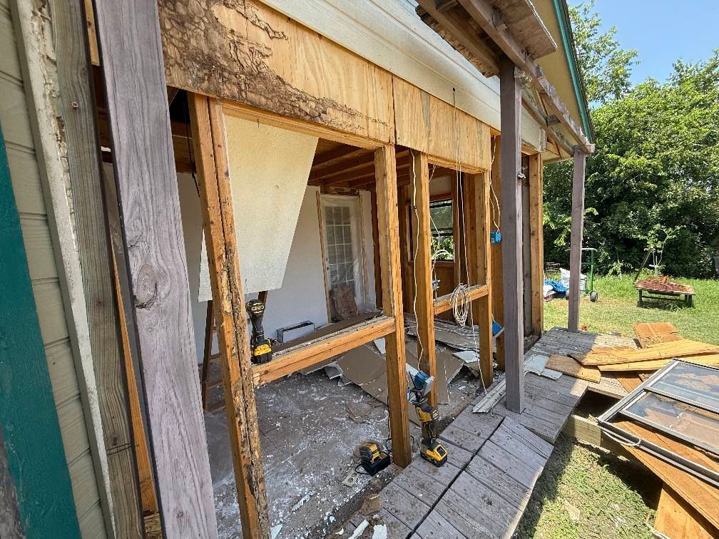 A house is being remodeled with a lot of wood being removed.