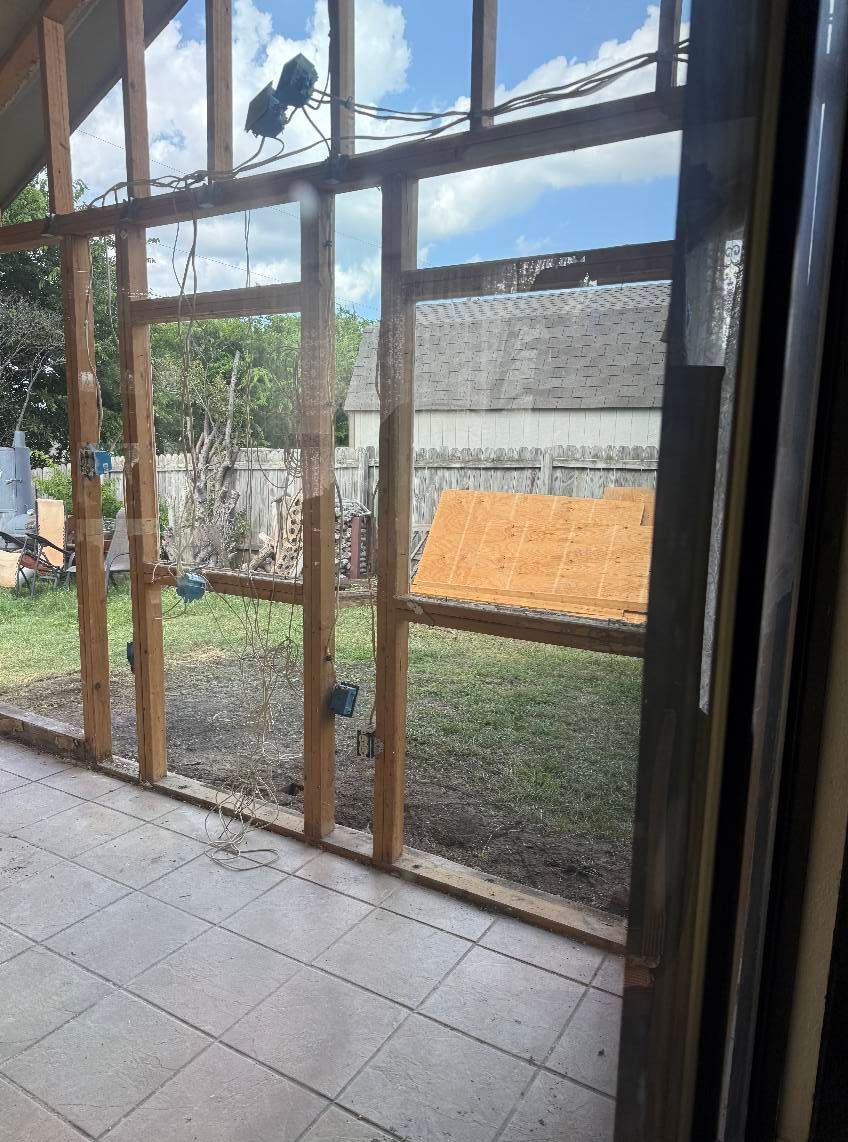 A room with a lot of windows and a fence in the background.