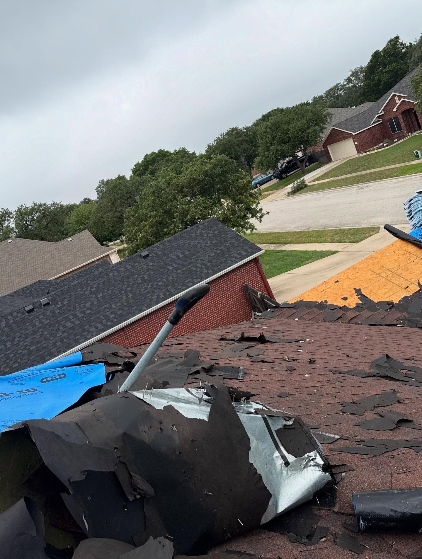 A car is laying on the roof of a house