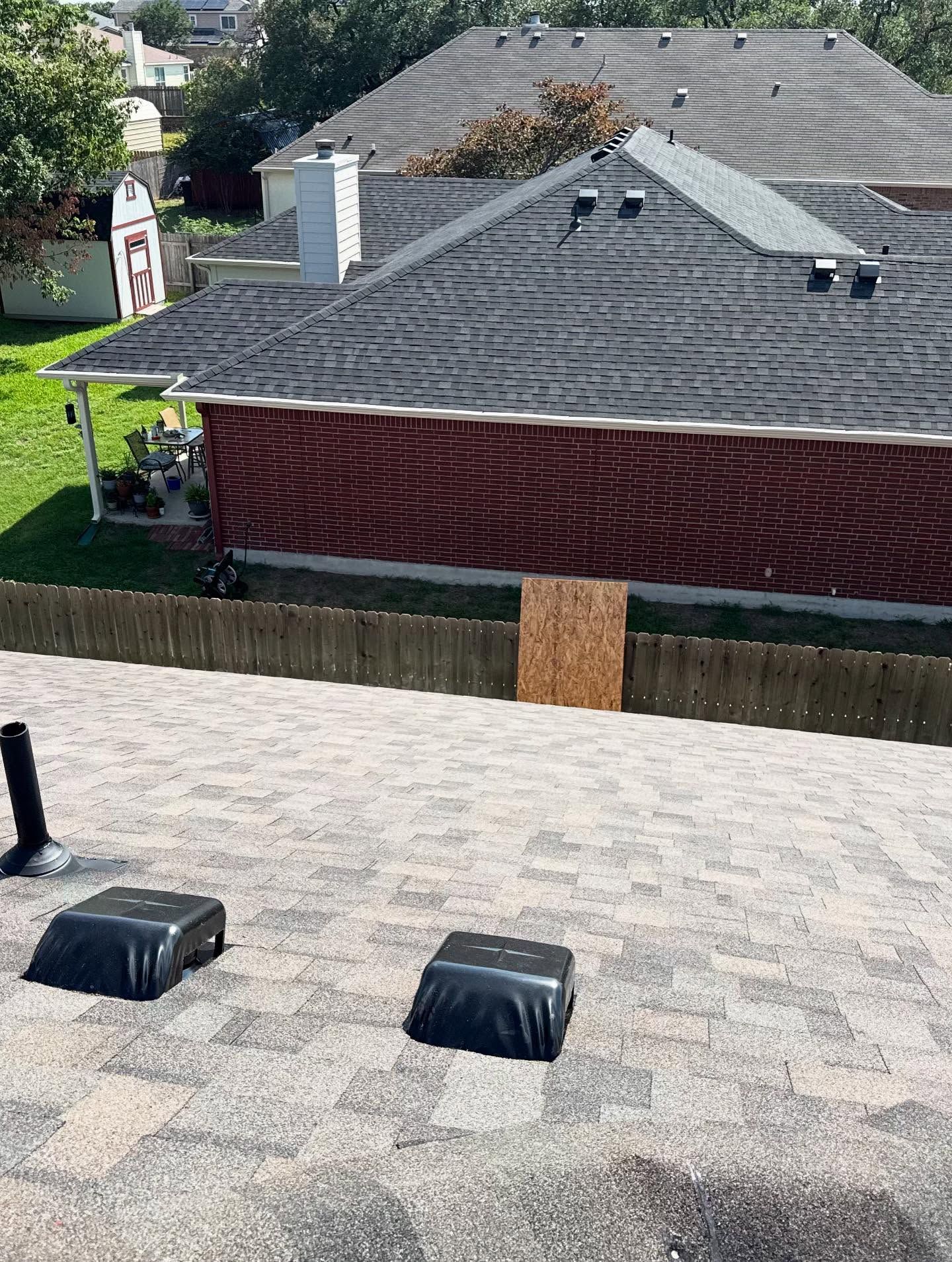 A house with a black roof and a red brick wall