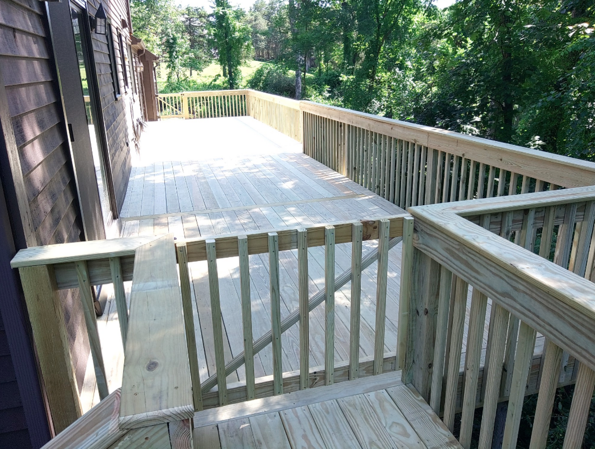 A wooden deck with a railing and stairs leading up to it