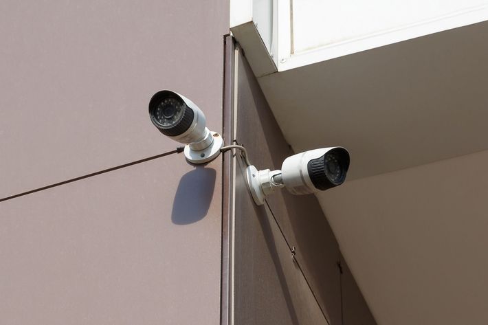 Due telecamere di sicurezza bianche montate sull'angolo di un edificio.