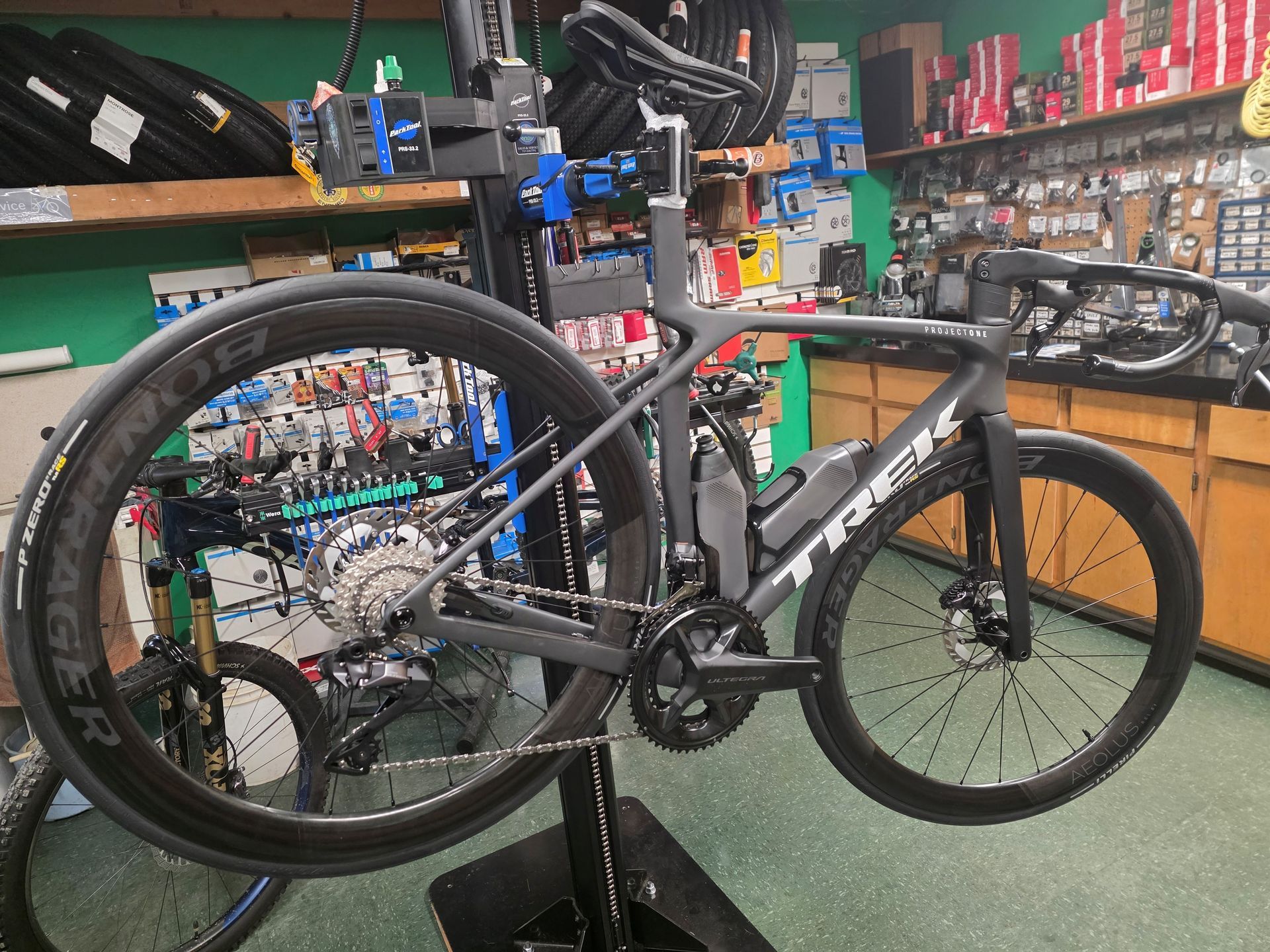 Mountain bike displayed in a bike shop, with black frame and colorful components.