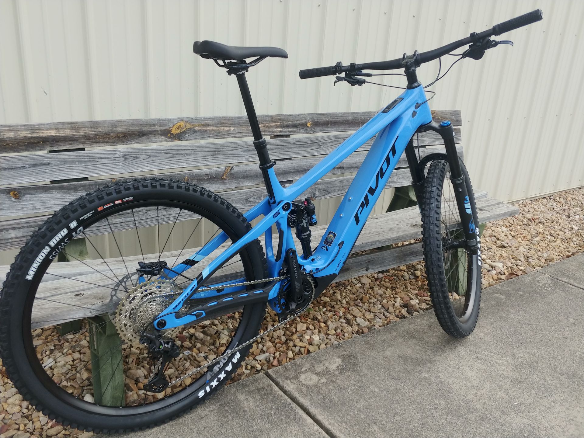Blue mountain bike leaning against a wall outdoors
