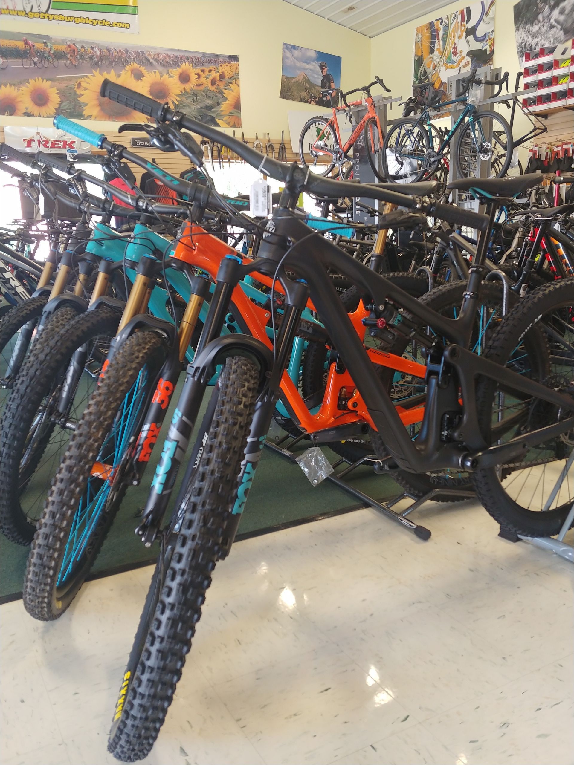 Rows of colorful mountain bikes packed together in a garage-like room.