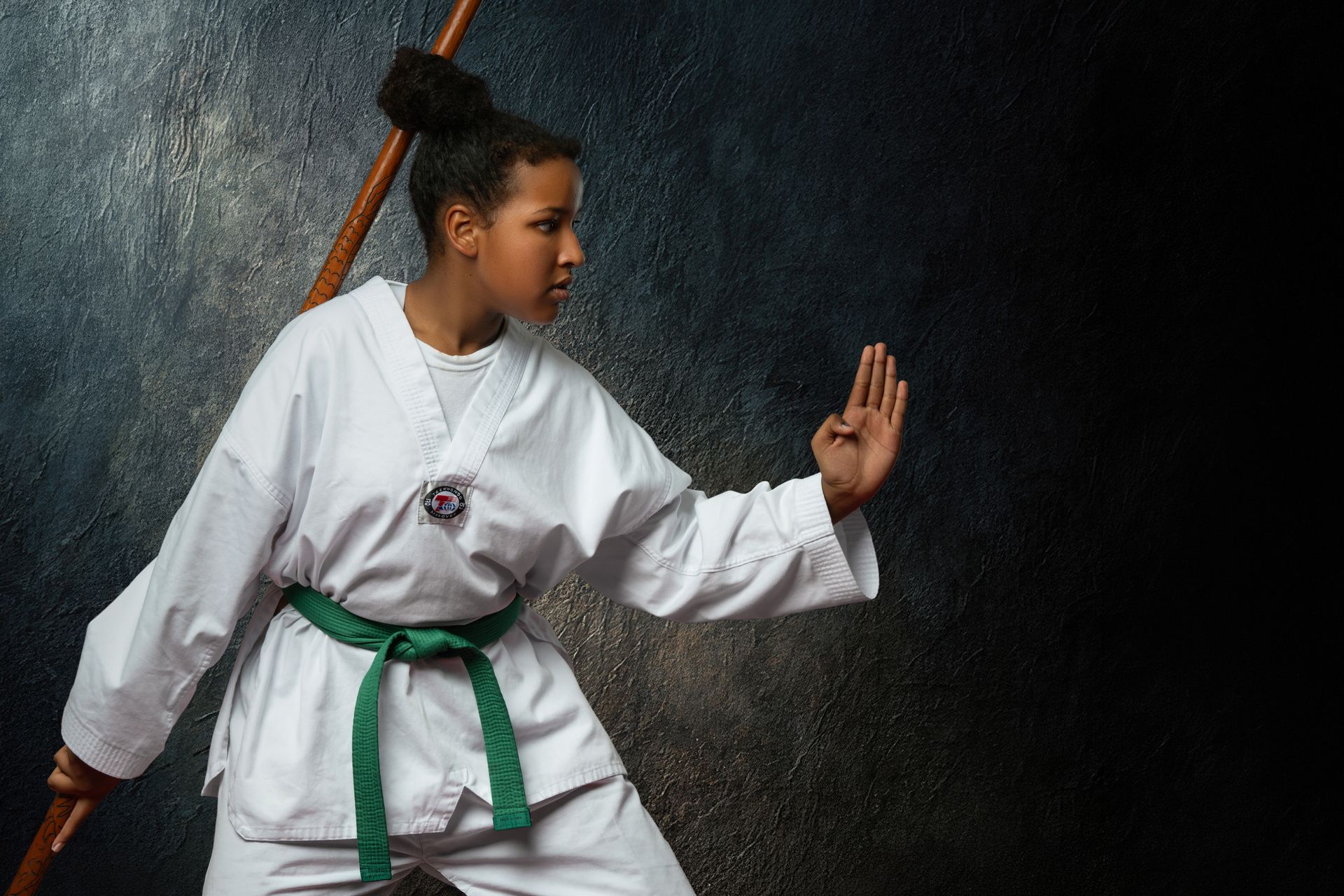 Five people in white and black martial arts uniforms pose for a photo in a training studio with a South Korean flag.