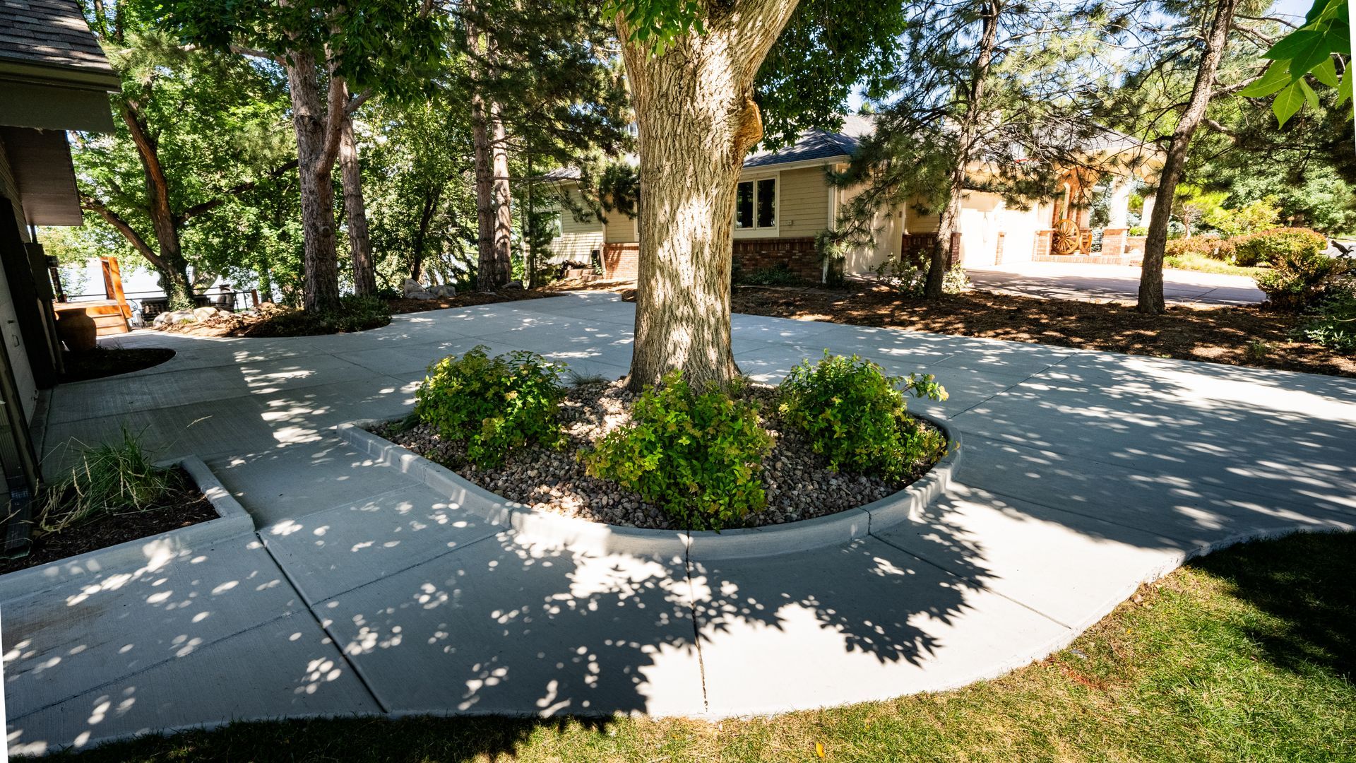 Single-story house with a large gravel driveway under a clear blue sky.