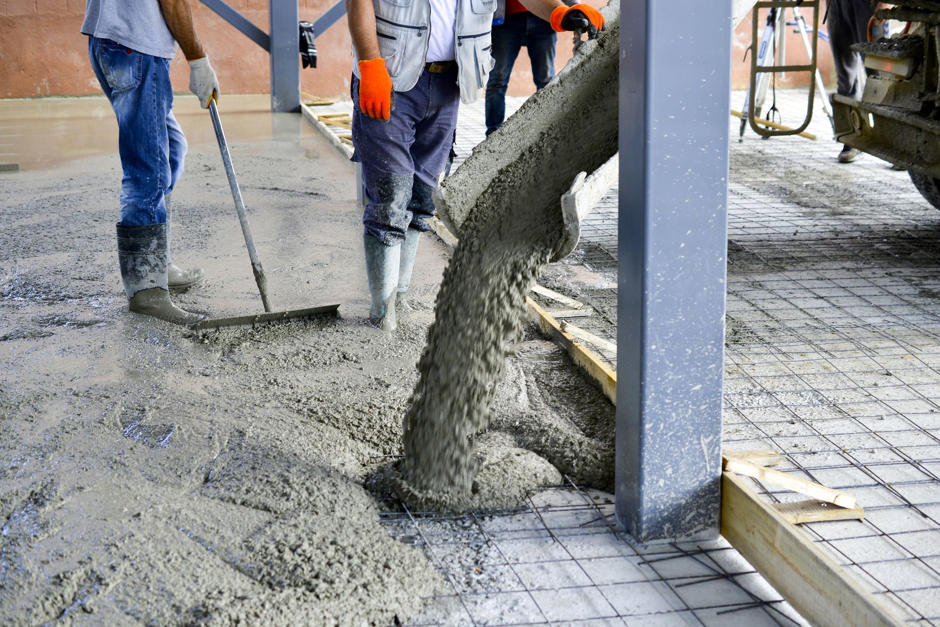 Workers pouring wet concrete at a construction site