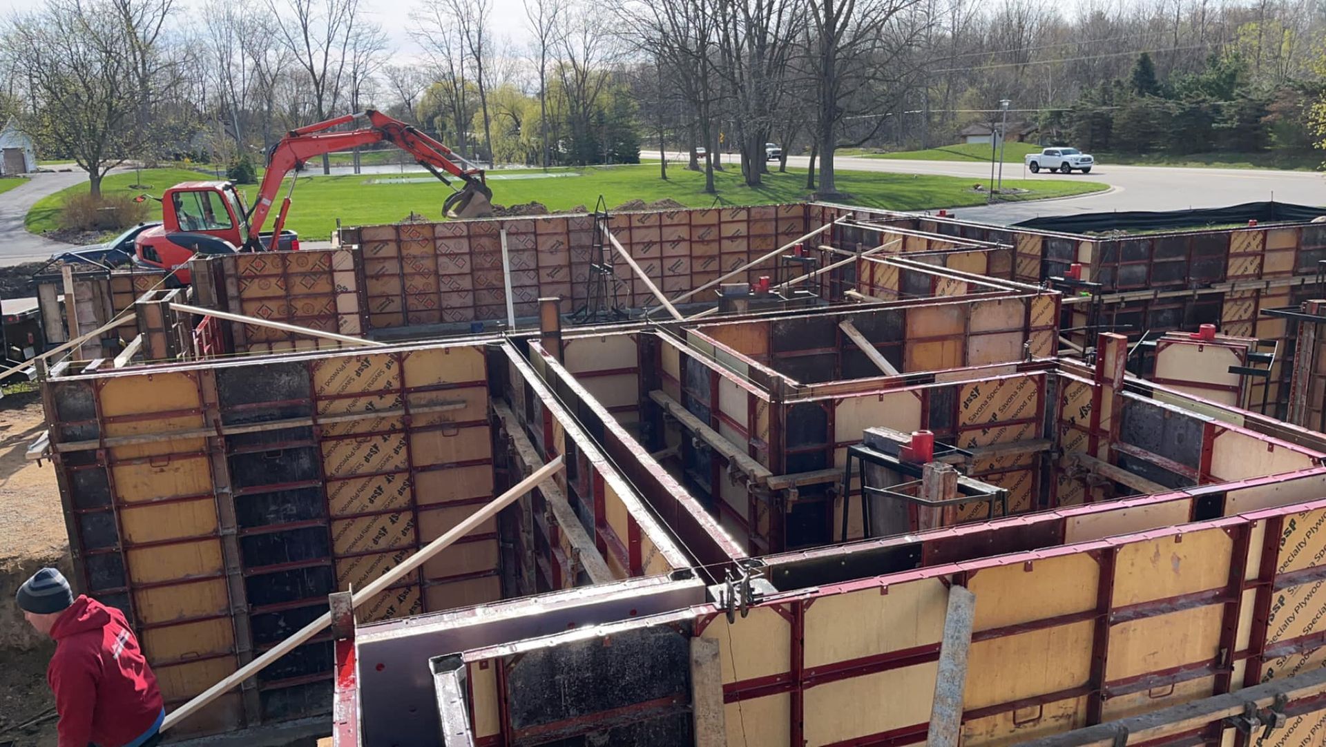 A construction site with a red excavator in the background.