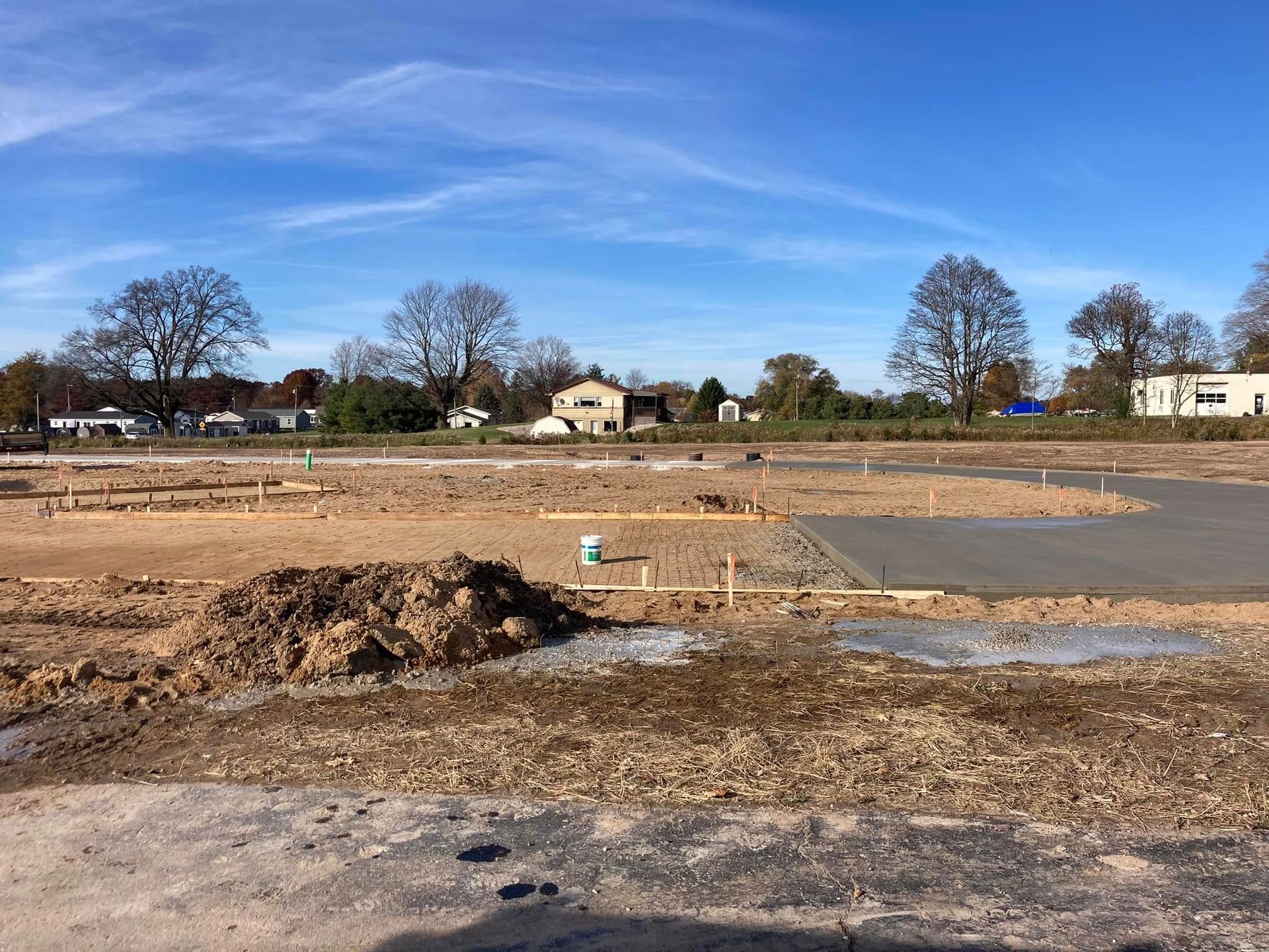 A construction site with a lot of dirt and trees in the background