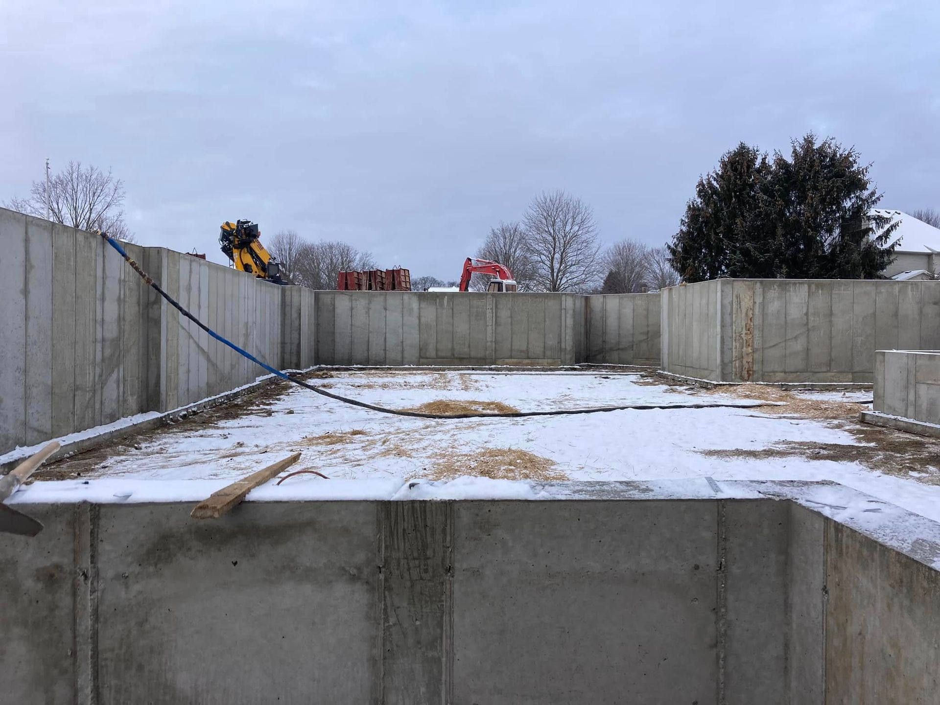 A concrete foundation is being built in the snow.